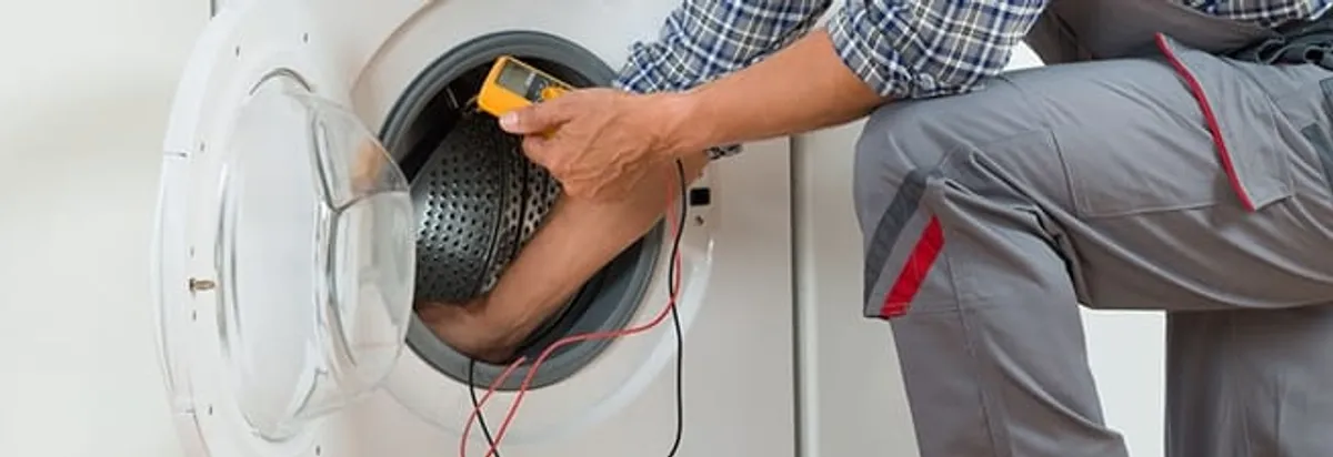 Dryer repair technician inspecting and repairing a clothes dryer in Riverside, CA