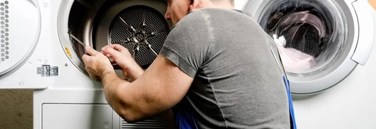 Dryer repair technician fixing a clothes dryer drum in Riverside, CA