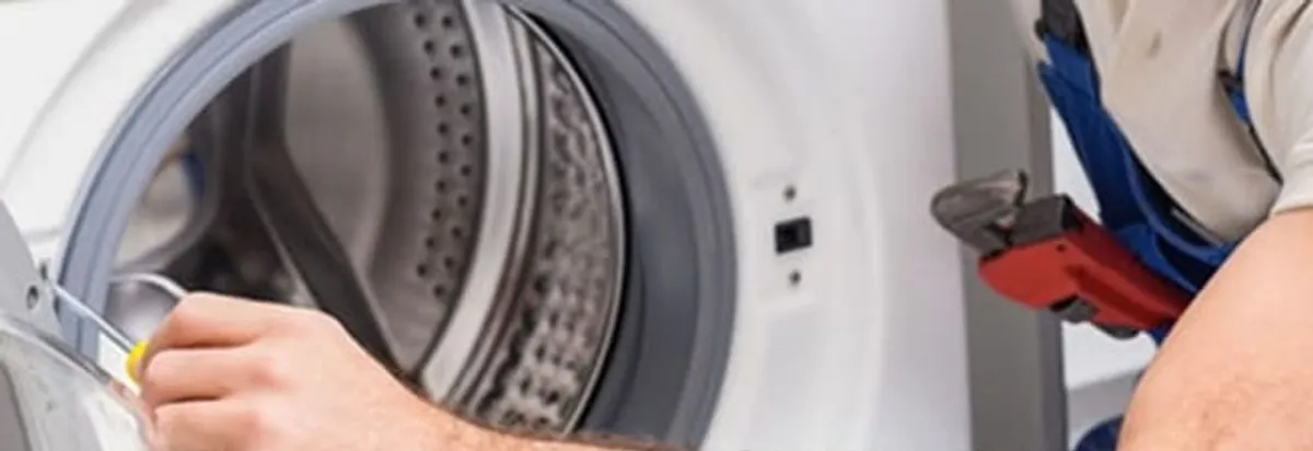 Appliance technician repairing a clothes dryer drum and internal parts in Riverside, CA